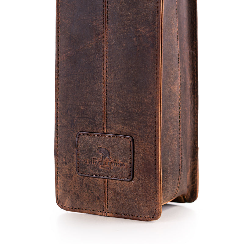 A close-up of the Banbury Wine Carry Bag by Vintage Leather Sydney shows its brown, weathered full-grain leather, visible stitching, and a rectangular patch embossed with a bear and Wild for Leather, set against a white background.