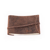 A closed Leather Photo Book Memo by Vintage Leather Sydney with visible stitching and a wraparound strap, shown lying on a white background.