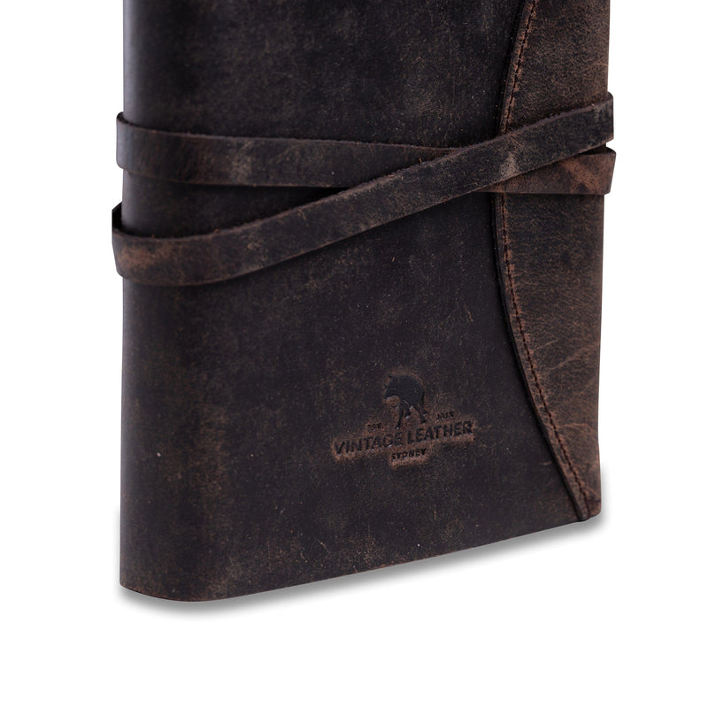 The Indigo | Journal Leather by Vintage Leather is a dark brown vintage buffalo leather journal with wrap-around strap, embossed helmeted figure, Vintage Leather on the cover, and handmade paper for an authentic writing experience.